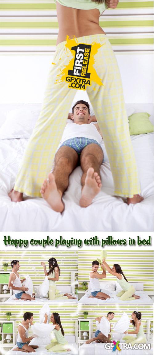 Stock Photo: Happy couple playing with pillows in bed