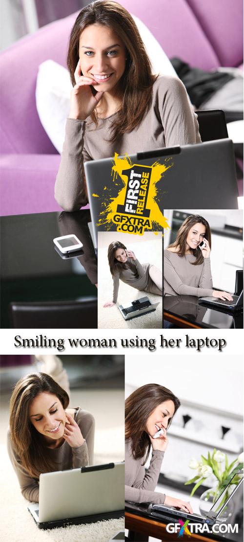 Stock Photo: Smiling woman using her laptop in the living room