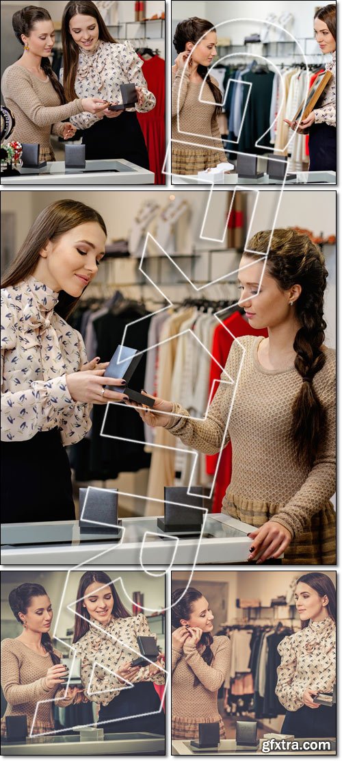 Young woman choosing jewellery with shop assistant help - Stock photo