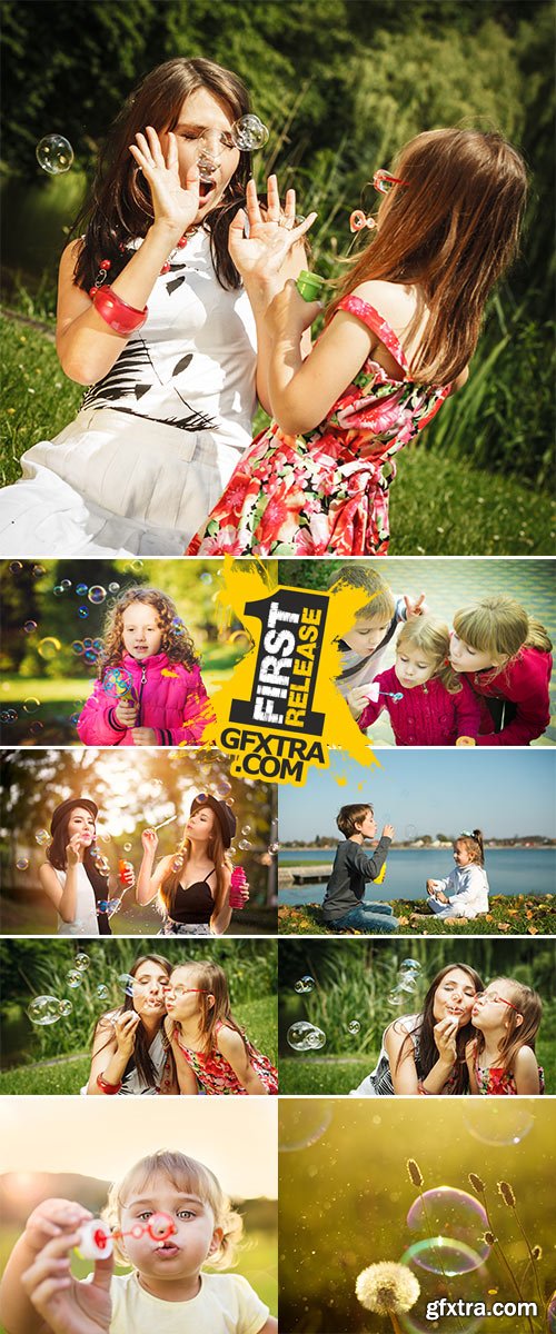 Stock Photo Little girl having fun blowing soap bubbles in park green blurred background