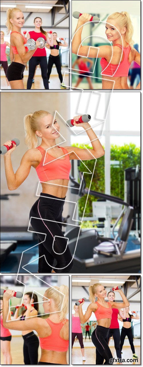 Smiling beautiful sporty woman with dumbbells - Stock photo