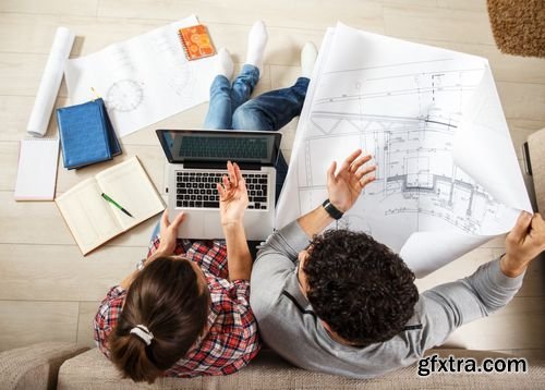 Stock Photos - Young Couple Examing Blueprints of they New House