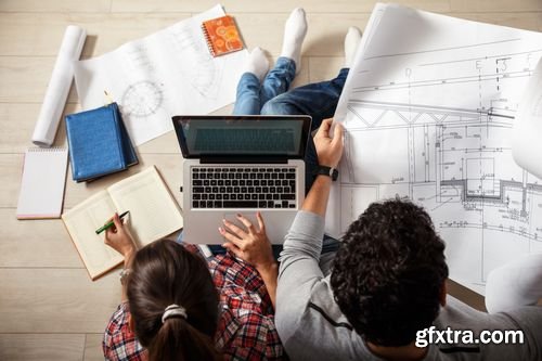 Stock Photos - Young Couple Examing Blueprints of they New House