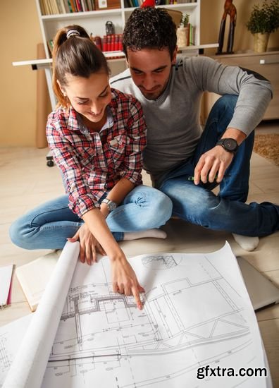 Stock Photos - Young Couple Examing Blueprints of they New House