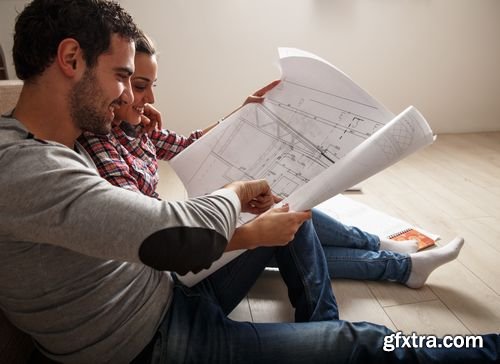 Stock Photos - Young Couple Examing Blueprints of they New House