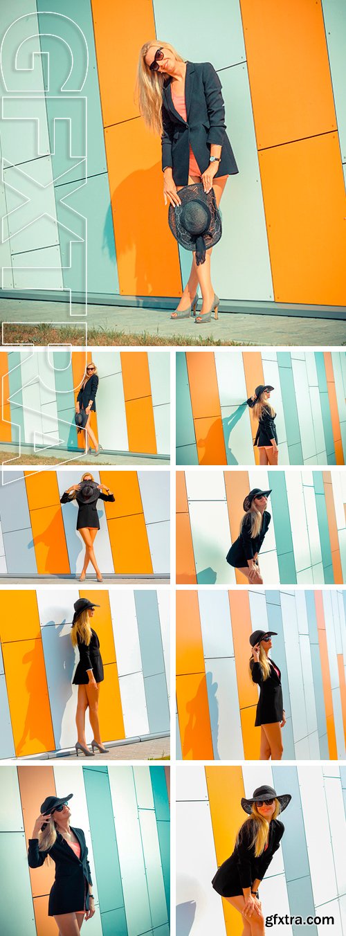 Stock Photos - Beautiful attractive trendy girl in long-skirted hat posing on the background orange wall