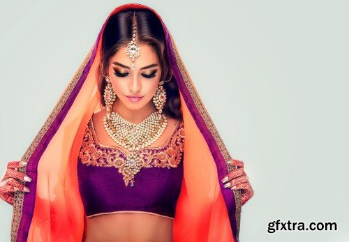 Portrait of beautiful indian girl, young hindu woman model with tatoo mehndi and kundan jewelry, traditional Indian costume lehenga choli