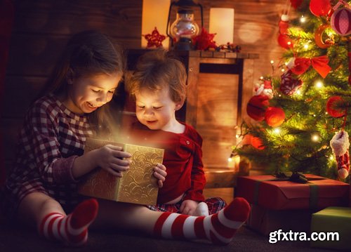 Happy family at Christmas, mother and daughter decorate the Christmas tree and exchange gifts