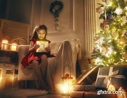 Happy family at Christmas, mother and daughter decorate the Christmas tree and exchange gifts