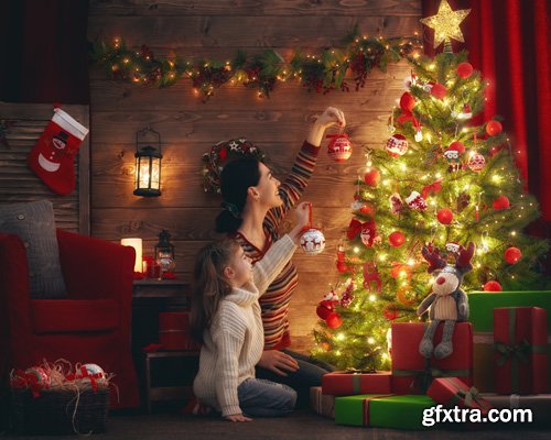 Happy family at Christmas, mother and daughter decorate the Christmas tree and exchange gifts