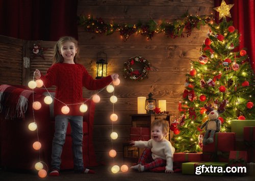 Happy family at Christmas, mother and daughter decorate the Christmas tree and exchange gifts