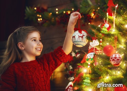 Happy family at Christmas, mother and daughter decorate the Christmas tree and exchange gifts