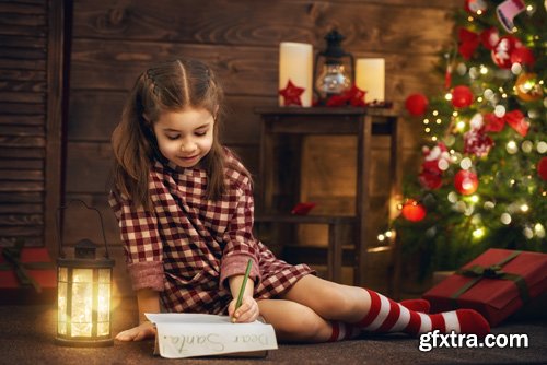 Happy family at Christmas, mother and daughter decorate the Christmas tree and exchange gifts