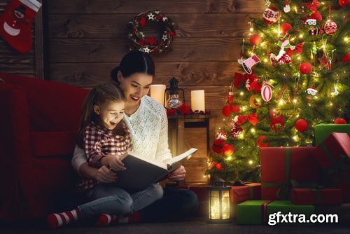 Happy family at Christmas, mother and daughter decorate the Christmas tree and exchange gifts