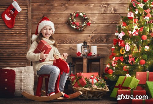 Happy family at Christmas, mother and daughter decorate the Christmas tree and exchange gifts