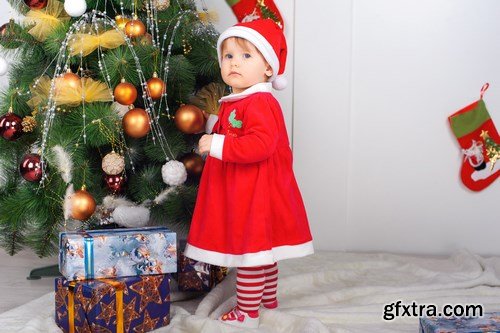 Cute little girl in Santa\'s suit near a Christmas tree - 19xUHQ JPEG Photo Stock