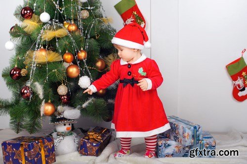 Cute little girl in Santa\'s suit near a Christmas tree - 19xUHQ JPEG Photo Stock