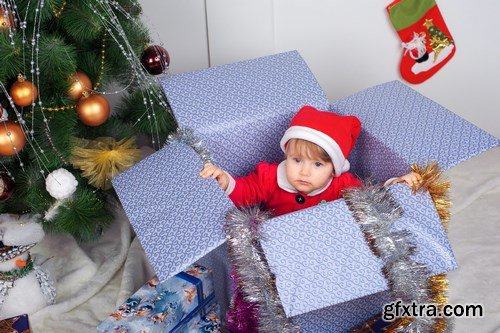 Cute little girl in Santa\'s suit near a Christmas tree - 19xUHQ JPEG Photo Stock