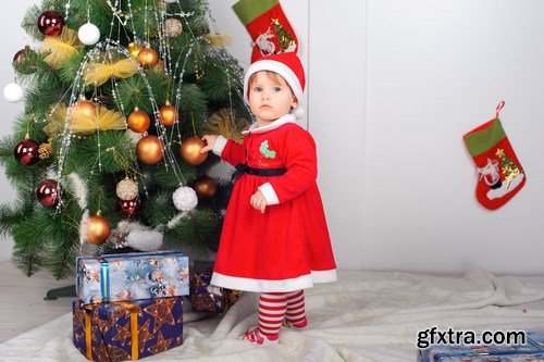 Cute little girl in Santa\'s suit near a Christmas tree - 19xUHQ JPEG Photo Stock