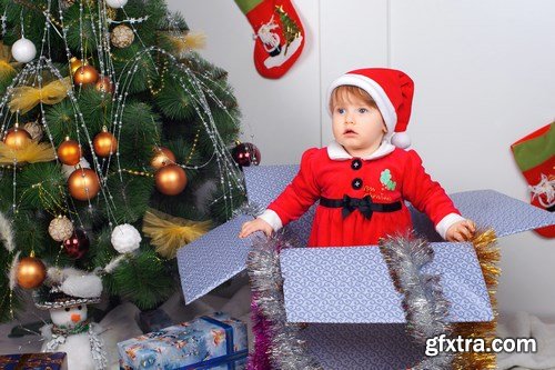 Cute little girl in Santa\'s suit near a Christmas tree - 19xUHQ JPEG Photo Stock