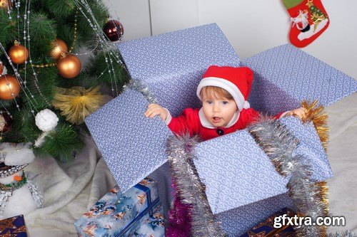 Cute little girl in Santa\'s suit near a Christmas tree - 19xUHQ JPEG Photo Stock