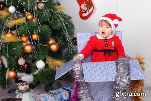 Cute little girl in Santa\'s suit near a Christmas tree - 19xUHQ JPEG Photo Stock