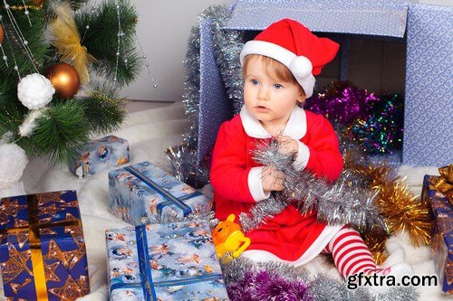 Cute little girl in Santa\'s suit near a Christmas tree - 19xUHQ JPEG Photo Stock