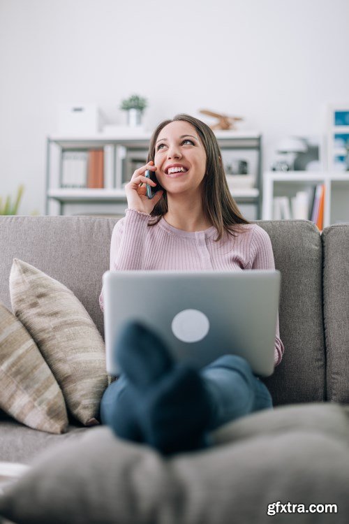 Beautiful young girl works with the smartphone and a laptop - 18xUHQ JPEG Photo Stock