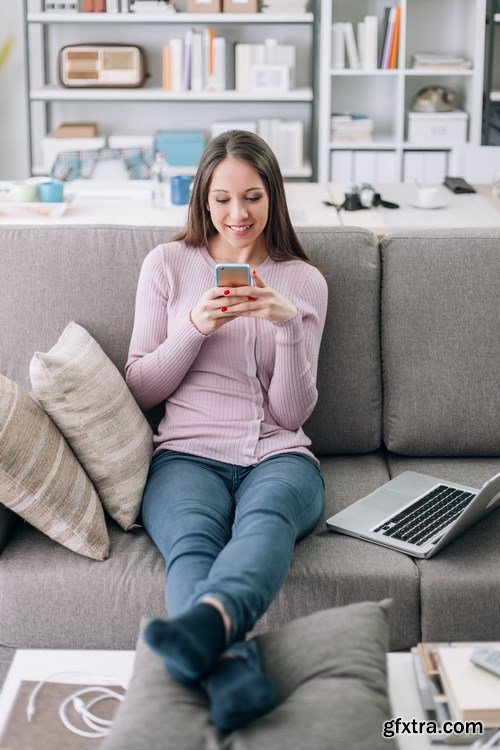 Beautiful young girl works with the smartphone and a laptop - 18xUHQ JPEG Photo Stock