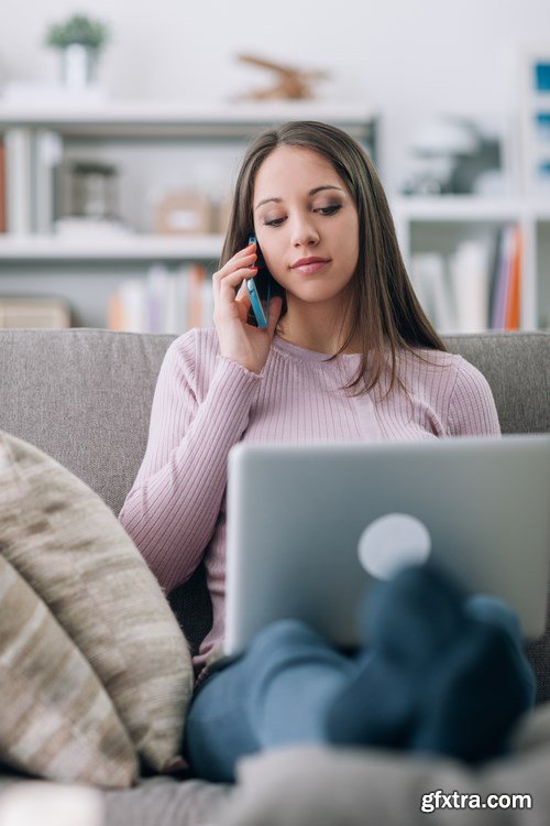 Beautiful young girl works with the smartphone and a laptop - 18xUHQ JPEG Photo Stock