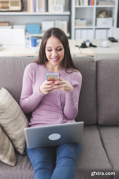 Beautiful young girl works with the smartphone and a laptop - 18xUHQ JPEG Photo Stock