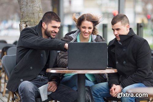 Group of students is sitting in an outdoor cafe and using laptop - 14xUHQ JPEG Photo Stock