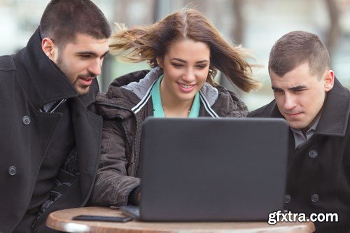 Group of students is sitting in an outdoor cafe and using laptop - 14xUHQ JPEG Photo Stock