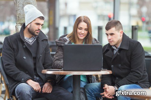 Group of students is sitting in an outdoor cafe and using laptop - 14xUHQ JPEG Photo Stock