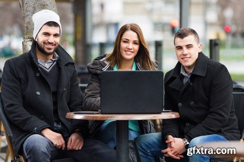 Group of students is sitting in an outdoor cafe and using laptop - 14xUHQ JPEG Photo Stock