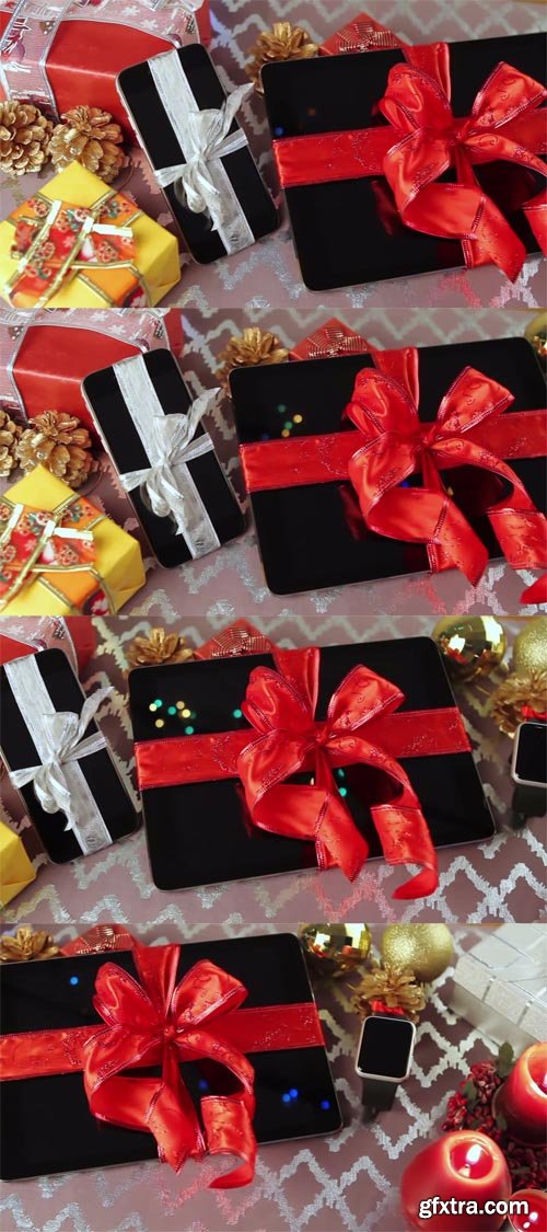 Tablet pc, smartphone and smartwatch for Christmas with gifts, decorations and candles on table