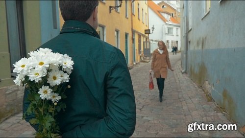 Slow motion of a happy girl running to her boyfriend and he meeting her with a bunch of flowers she