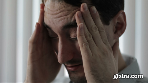 Man rubbing his temples with a headache