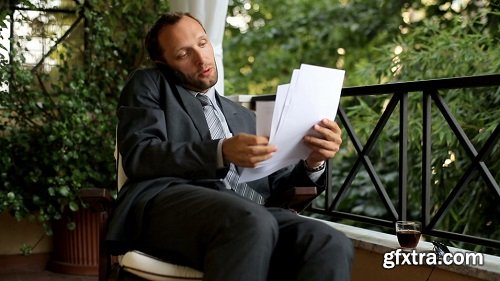 Angry businessman with cellphone after hard work on his balcony at home