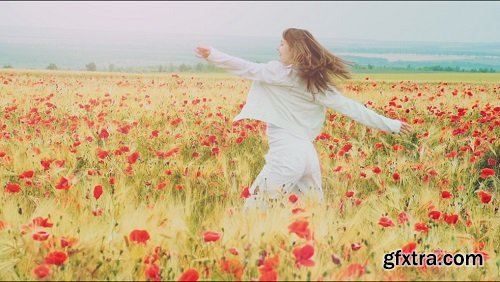 Young attractive woman dressed in white clothes is running-through a poppies field feeling happy and free slow motio filmed at 250-fps