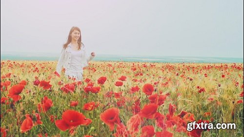 Young attractive woman dressed in white clothes is running-through a poppies field feeling happy and free slow motio filmed at 250-fps