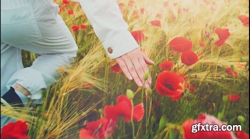 Young attractive woman dressed in white clothes is running-through a poppies field feeling happy and free slow motio filmed at 250-fps