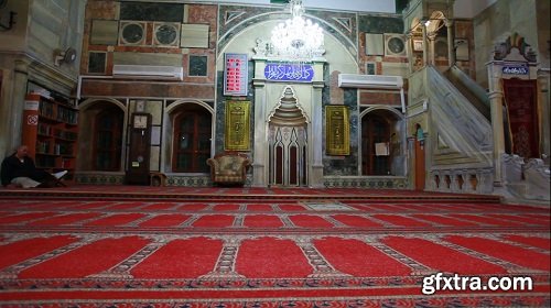 Interior shot of mosque with people engaged in prayer 3