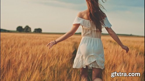 Beautiful girl running on sunlit wheat field slow motion 120 fps freedom concept happy woman having
