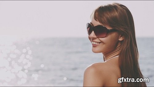 Beautiful young woman in bikini is styling her hair on the sea beach sunny summer by the sea