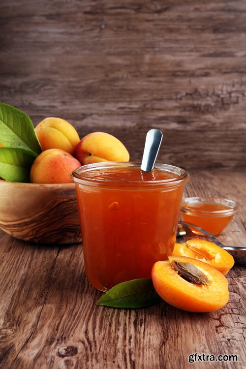 Apricot jam in glass bowl with fruit around