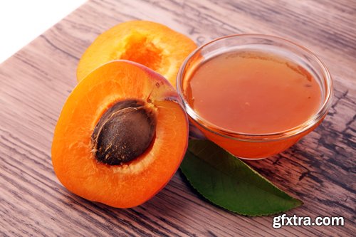 Apricot jam in glass bowl with fruit around