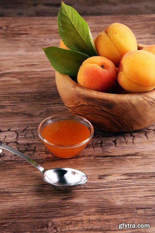 Apricot jam in glass bowl with fruit around