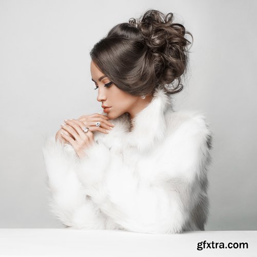 Fashion studio portrait of beautiful lady with elegant hairstyle in white fur coat