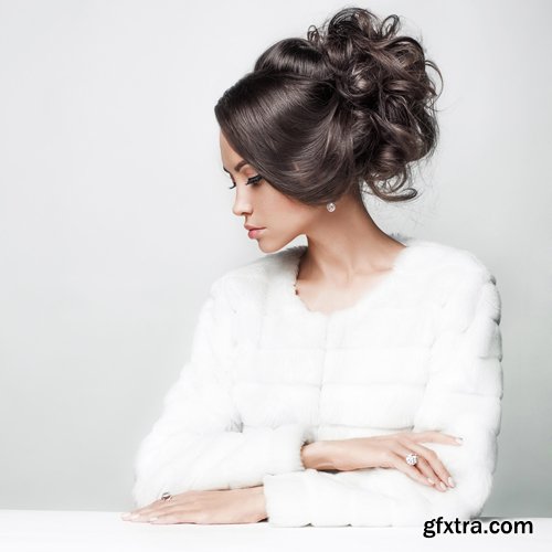 Fashion studio portrait of beautiful lady with elegant hairstyle in white fur coat